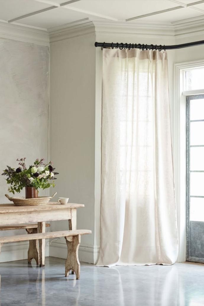 Byron &amp; Byron Metamorph bay pole in black on a corner window with linen curtains